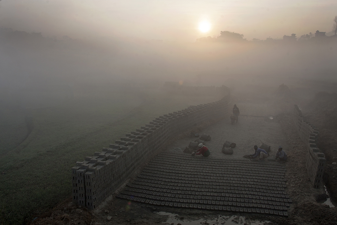 A family engaged in making bricks early in the morning during cold winter in Nalinchowk, Bhaktapur. In hilly region of Nepal, bricks are made during winter starting from November until April.