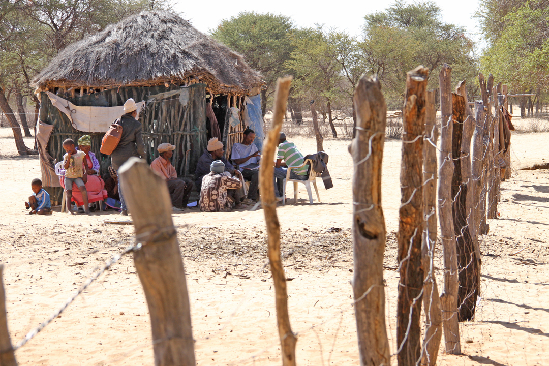 The Basarwa family, also known as bushmen, gather besides their hut to keep out of the harsh heat from the sun. The shelter is usually built with mud and branches.