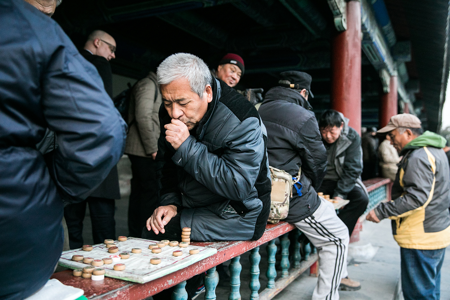 A man warms up his hands between plays. Even though it is only a mere 7°C, people are still outside, enjoying the gardens of the Temple, as well as each others company.