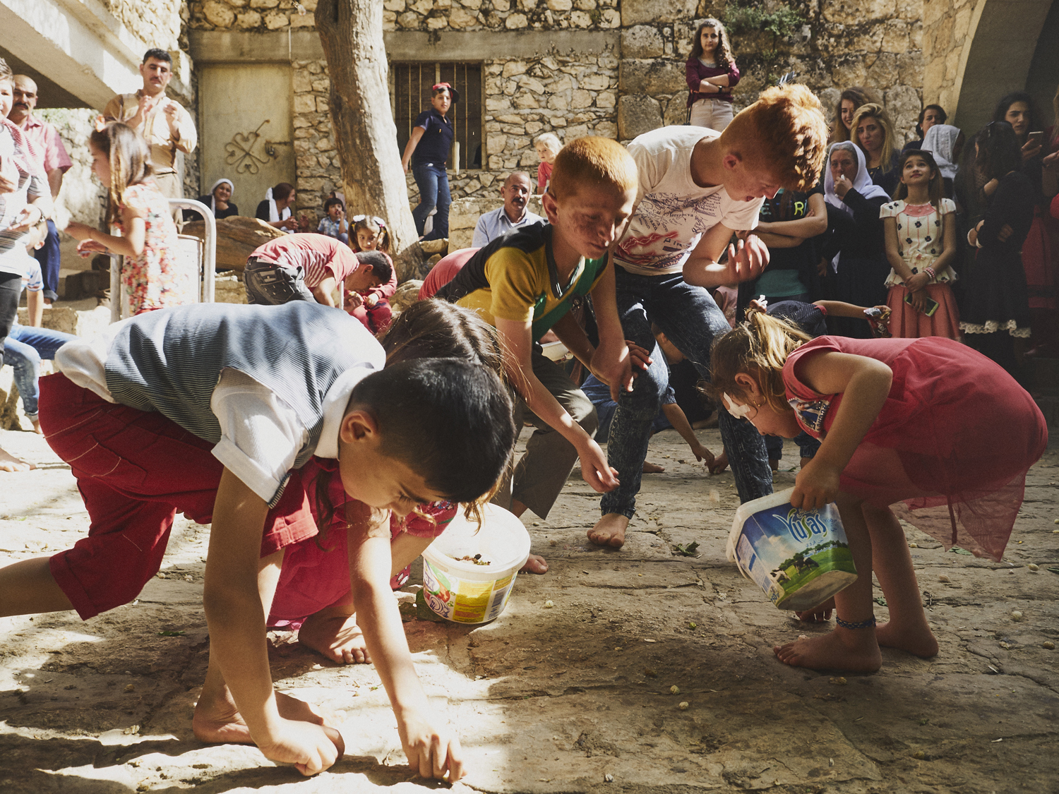 Lalish, Northern Iraq. In the years since the Yazidi genocide, visitors to this courtyarded complex have increased tenfold as families make the pilgrimage across Kurdistan. Children pick mulberries from the floor as their parents form queues to perform ancient rituals and respect their religion.