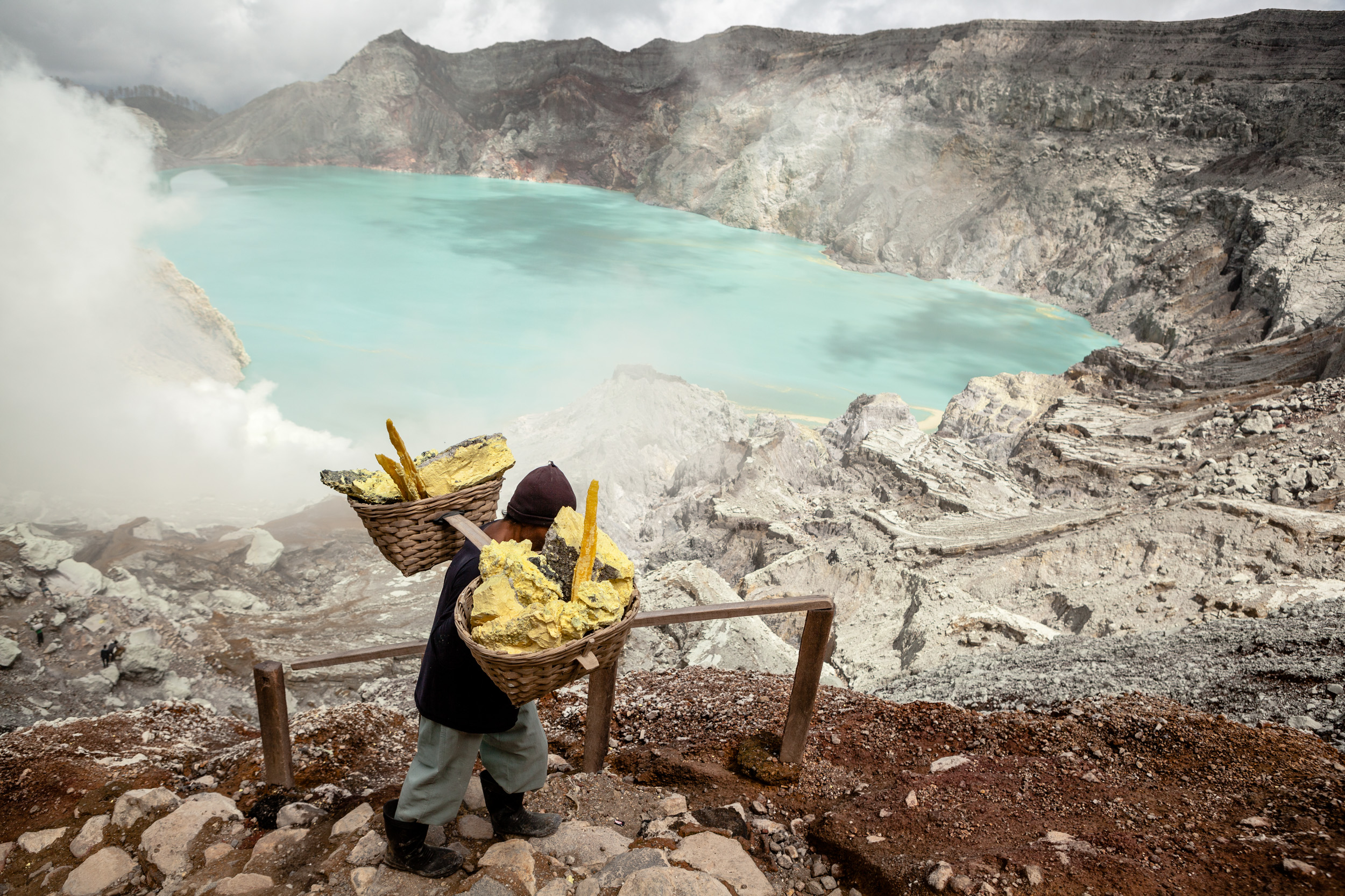 East Java, Indonesia. In the volcanic crater of Kawah Ijen, filled with a turquoise, extremely acid lake, miners carry inhuman loads of sulfur on their shoulders, from the bottom to the peak.