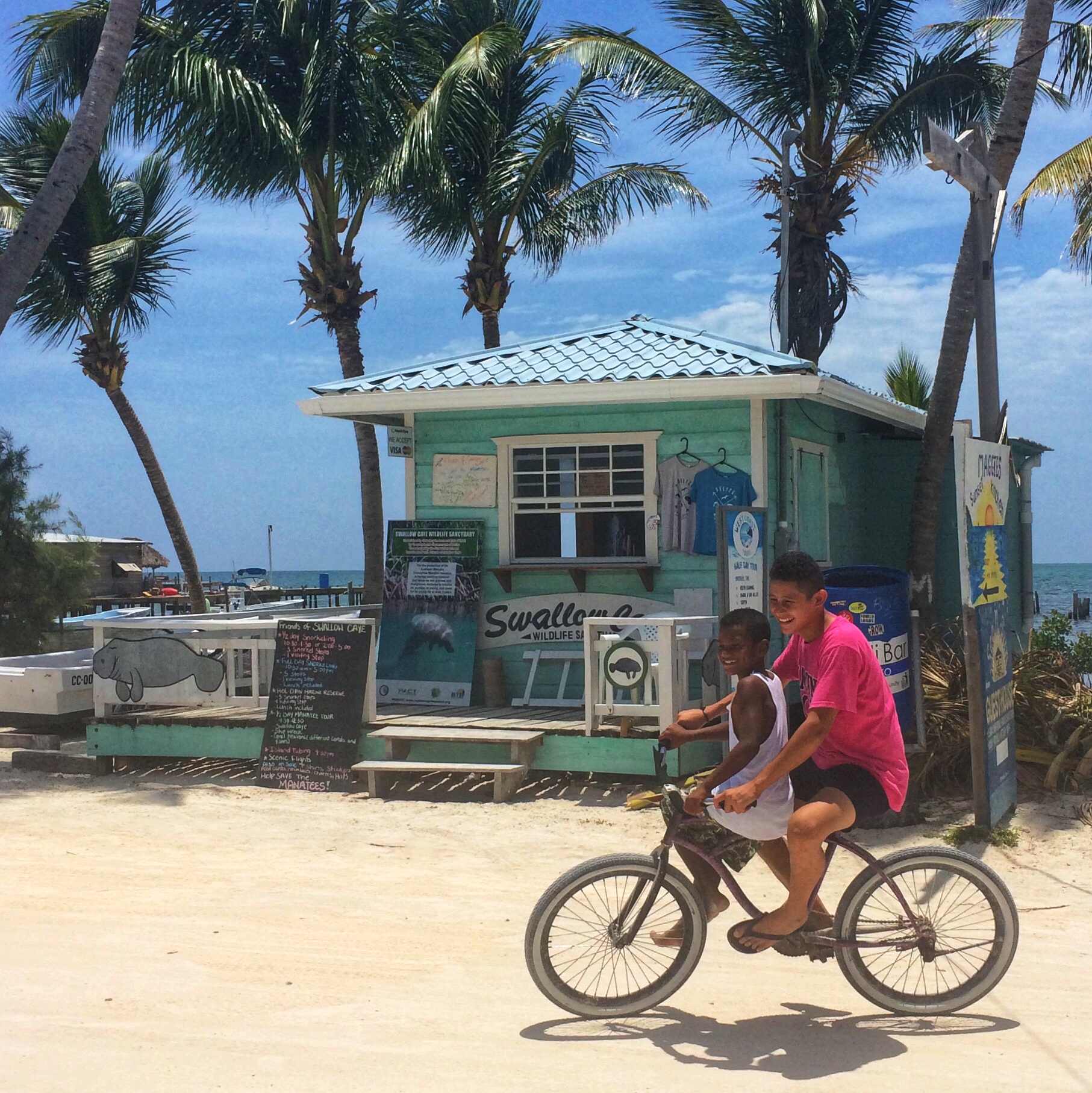 Spontaneous happiness. Kids riding a bicycle in Caye Caulker, Belize. 