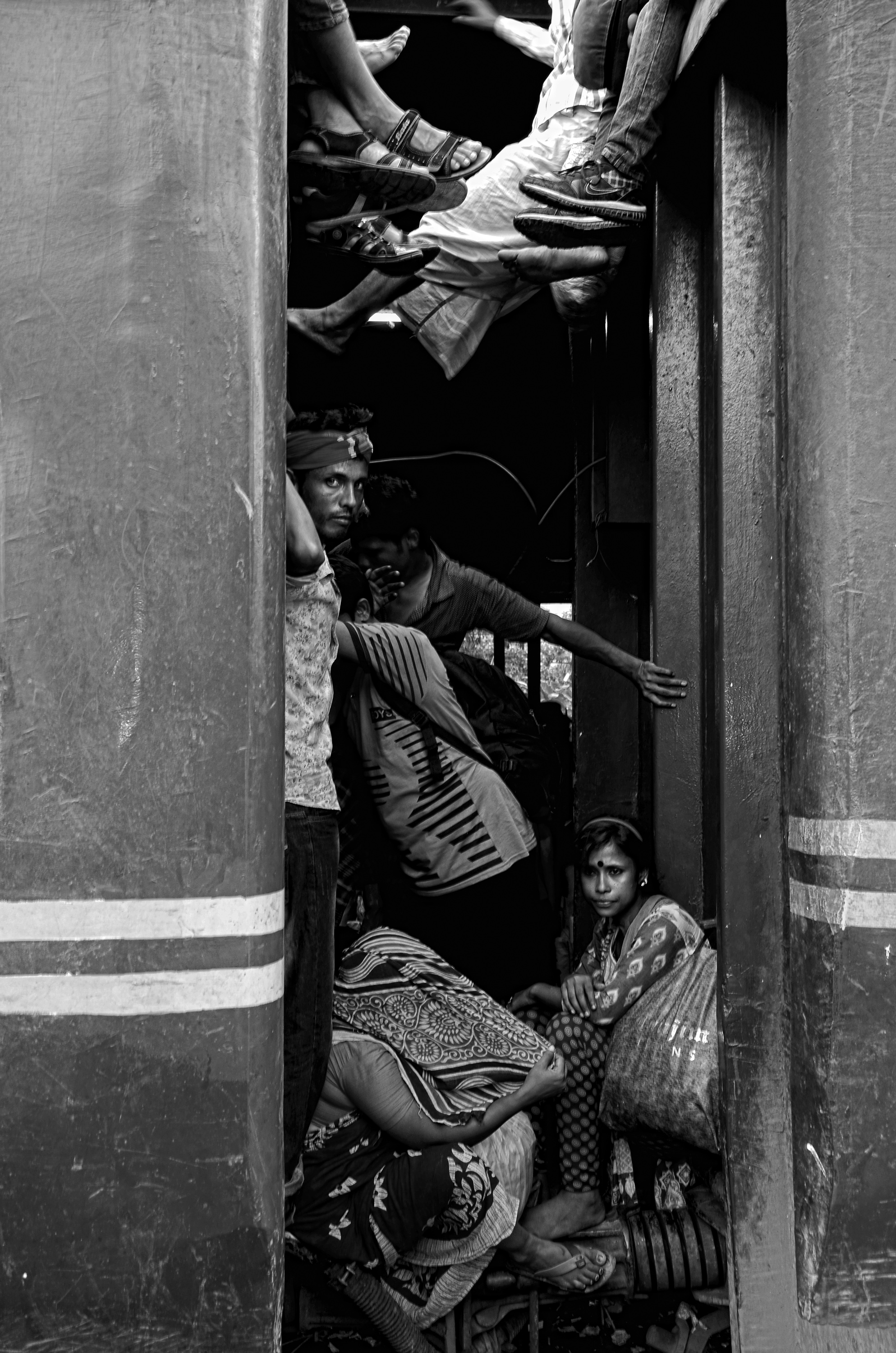Some passengers trying to by seating between two bogies of train in the platform, they want to reach their home at any cost for celebrating the biggest festival Eid.
