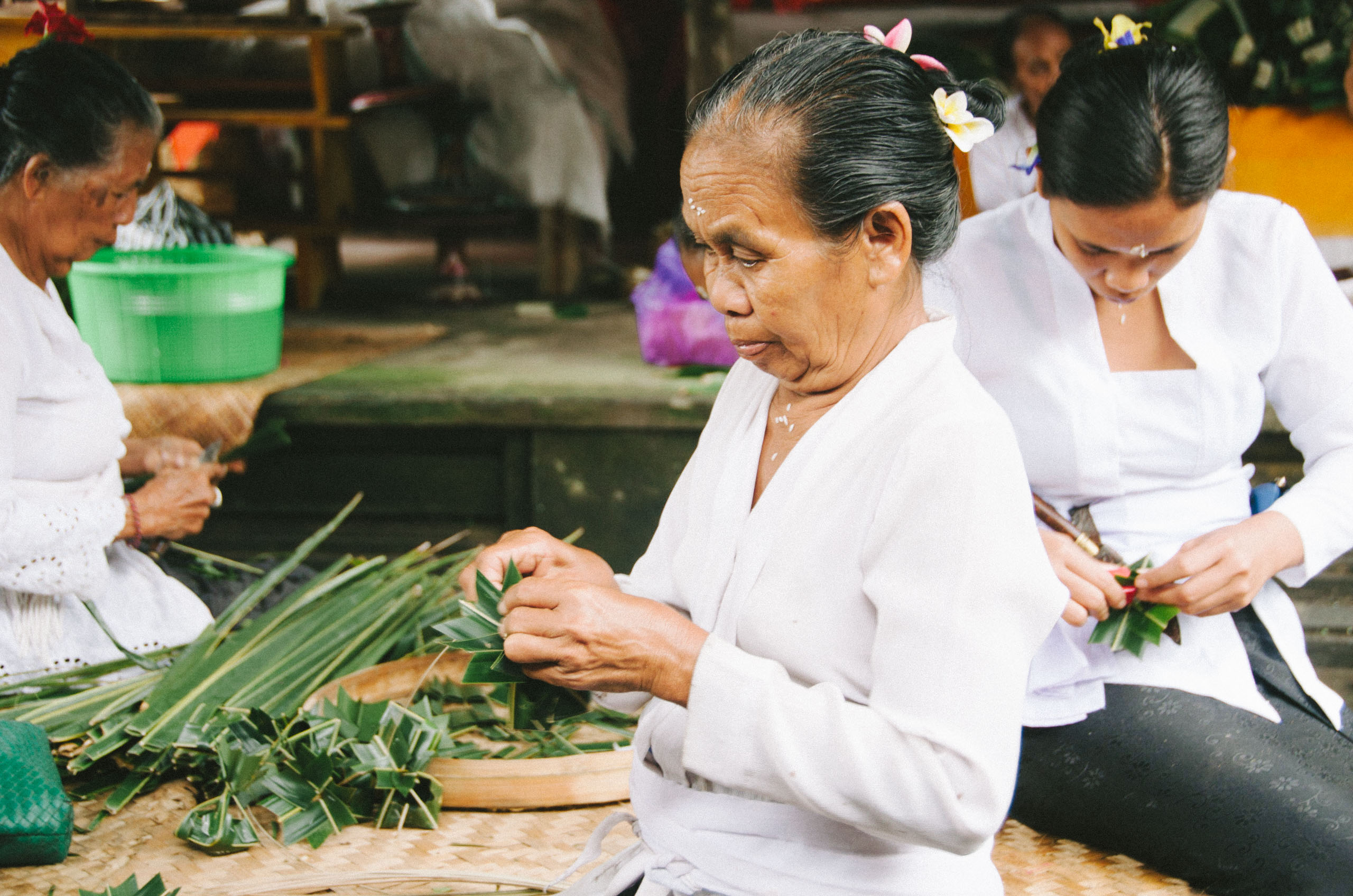 Women on the western edge of Bedulu Village preparing the special and often artistic offerings for their temple consisting of palm leaves, fruit, rice, sweets and incense.