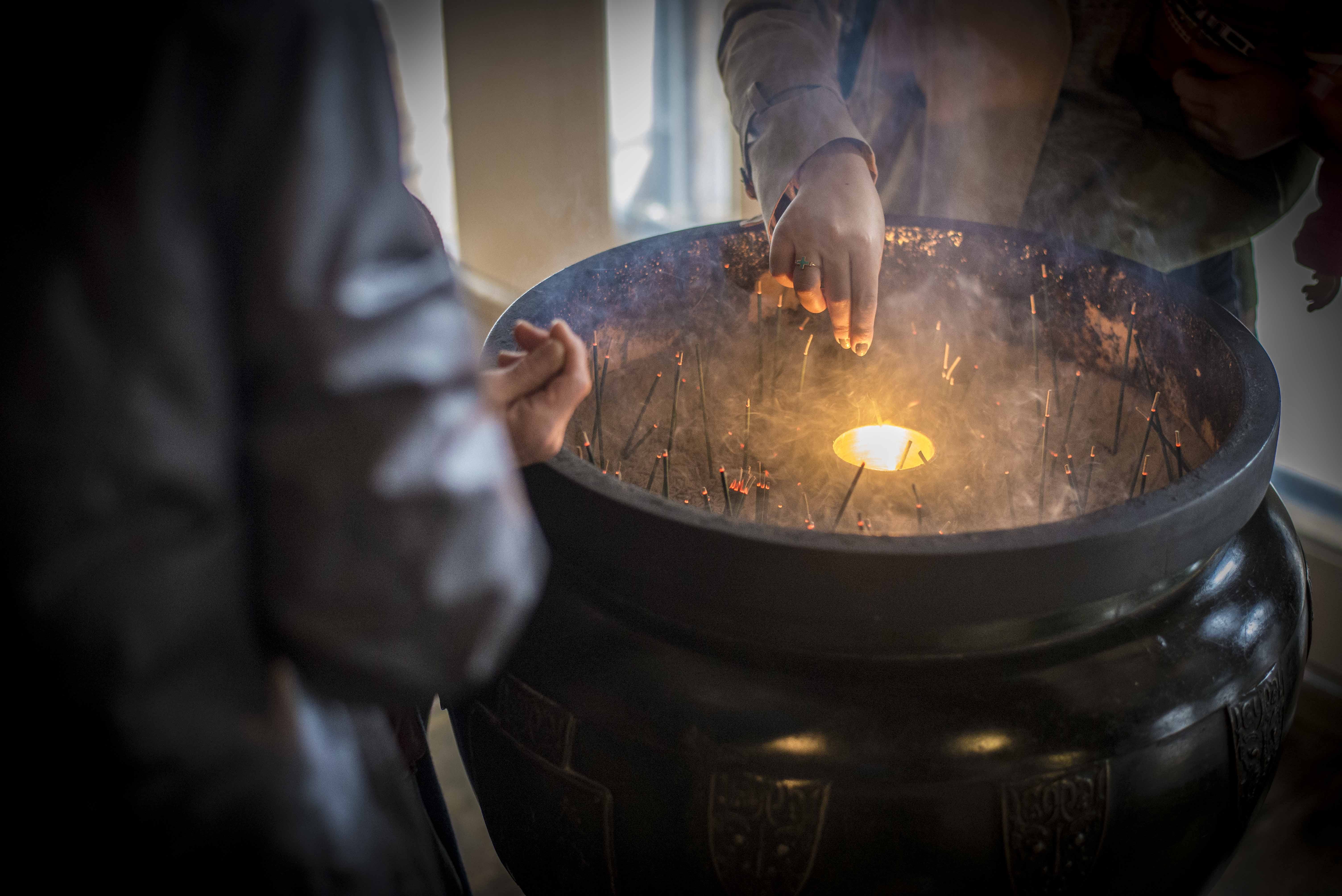 Devotees of Buddhism burn incense as an offering to the gods at Kiyomizu-dera temple.