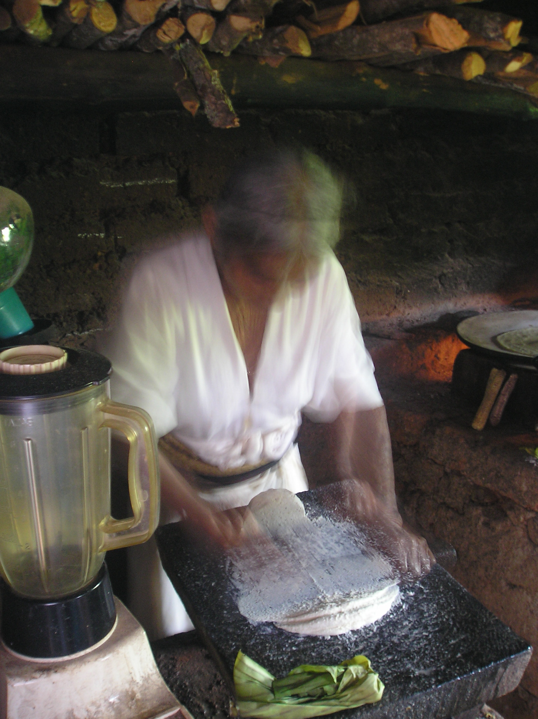 Abuelita Emiliana in her dark kitchen making the masa for the traditional Tlayudas.