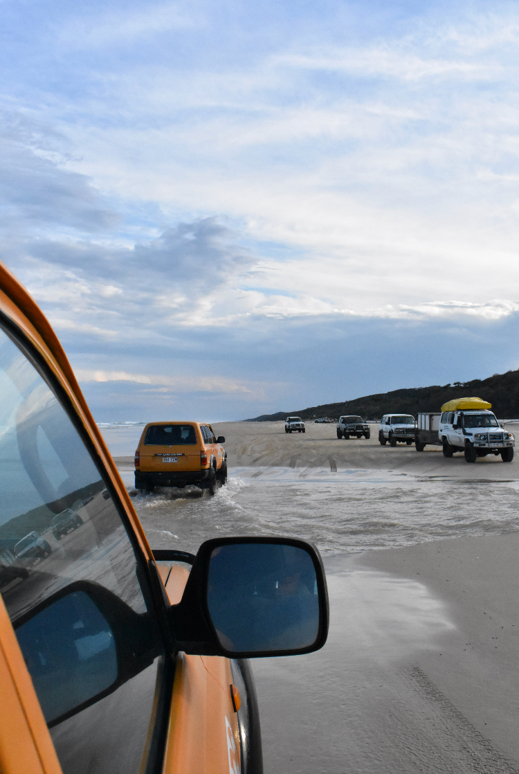 As the morning breaks in, Toyota Land Cruisers, shaded yellow, convoy south. Passing another tour group as the machines power through the salt water.