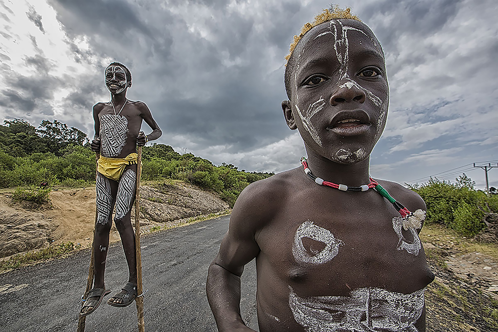 'Boys on Stilts' - Pictured is two Hamar tribe boys who fashioned themselves a pair of makeshift stilts out of sticks. 