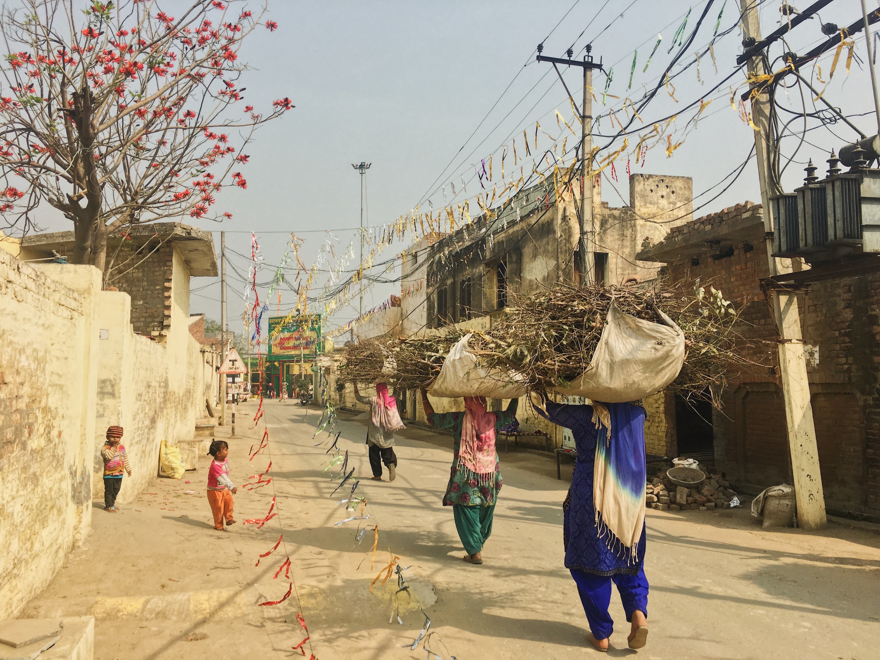 There is an existing gap in education between boys and girls, specifically in villages. Girls tend to leave school early to take on responsibilities at home. In photograph: Young women carrying sweepings.