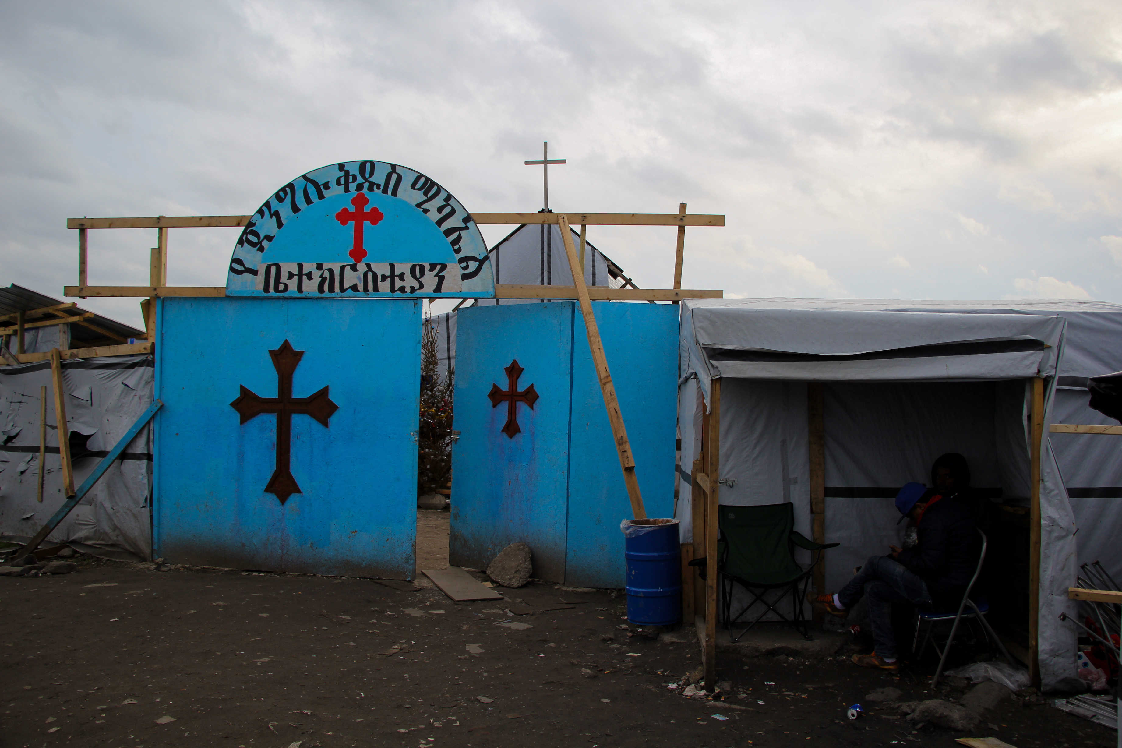 A makeshift Church stands in contrast to the many tents and tarp structures scattered throughout the refugee settlement. Structures such as these served as symbols of migrants' continued resilience and dedication to community and culture.