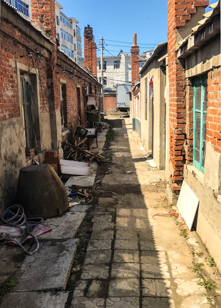 The view of the happy little girl stepping out of her home and heading towards the wasteland ahead to scavenge some more treasurable finds. (Town Liaozhong, Shenyang, Liao ning, Rural China)