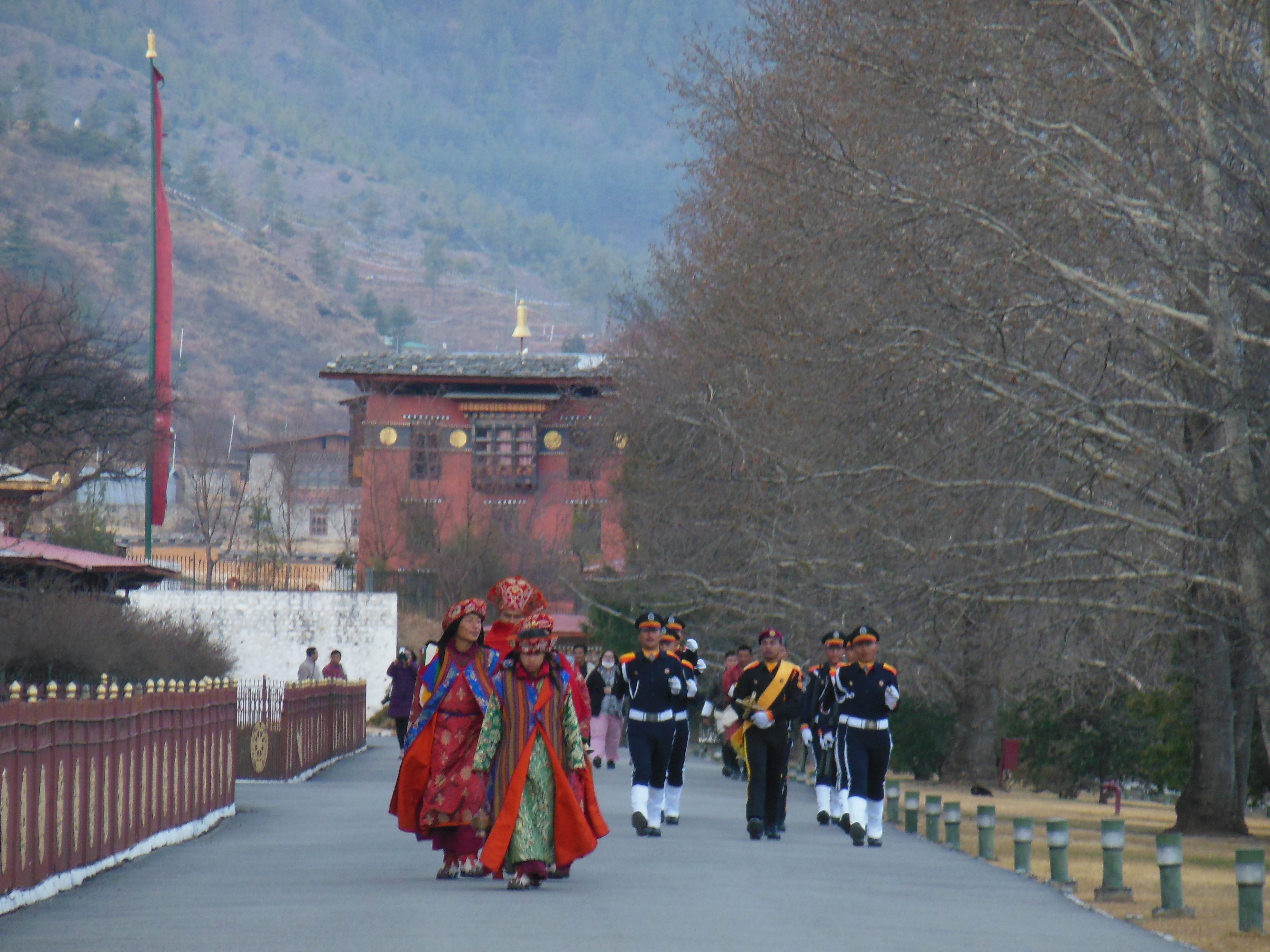 At sunset every evening, soldiers march and lower the Bhutanese flag in front of Trashichho Dzong, whilst the priests accompany for chanting & playing a tune. This Dzong is the seat of the government since 1952, and the residence of the Royal family of Bhutan.