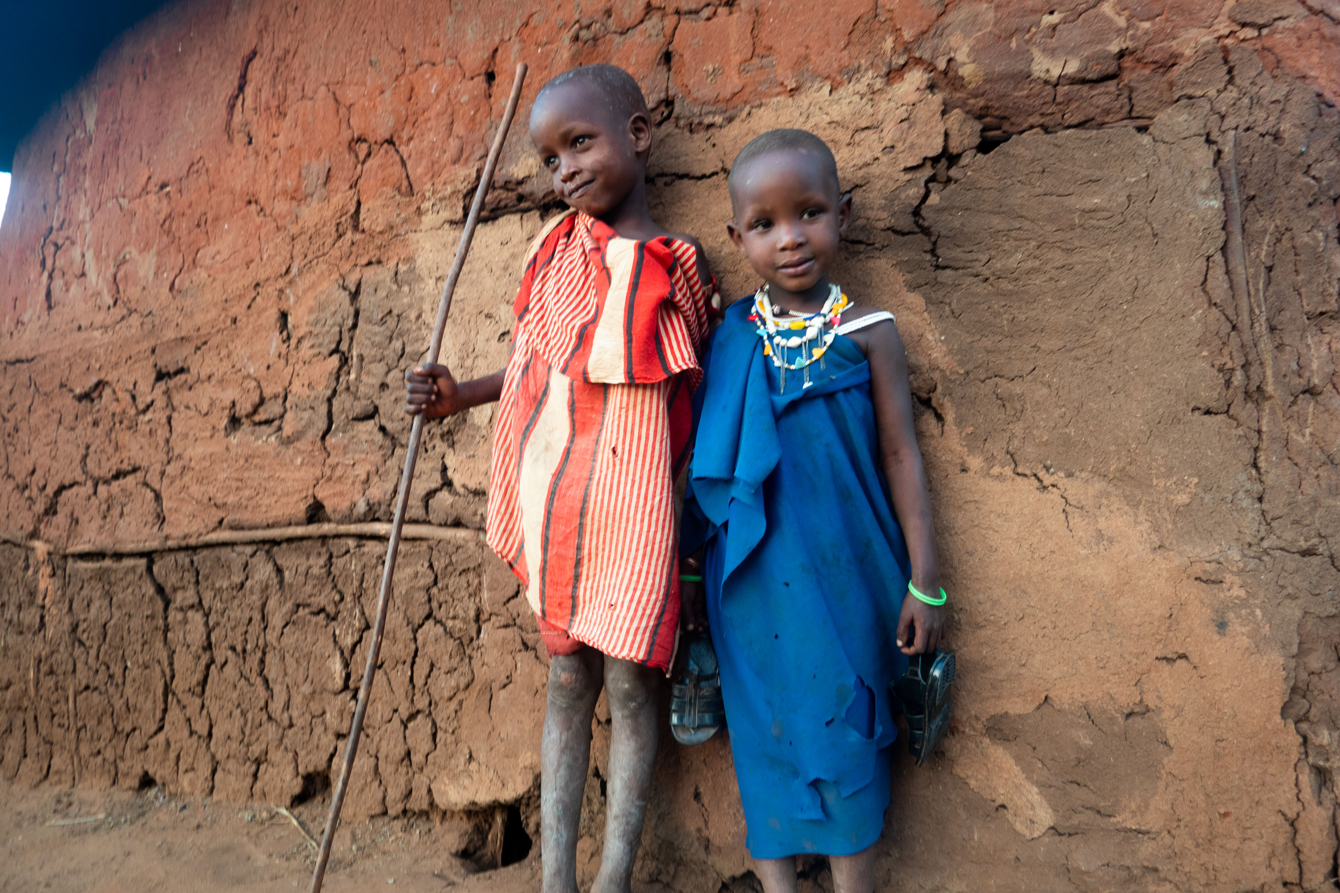 Brother and sister: Kimani (L) and Nditolai (R) stand side by side outside of their family hut. Nditolai will learn to do household chores from her mother, while Kimani will herd cows until his circumcision ceremony, which will mark his entry into respected manhood. 