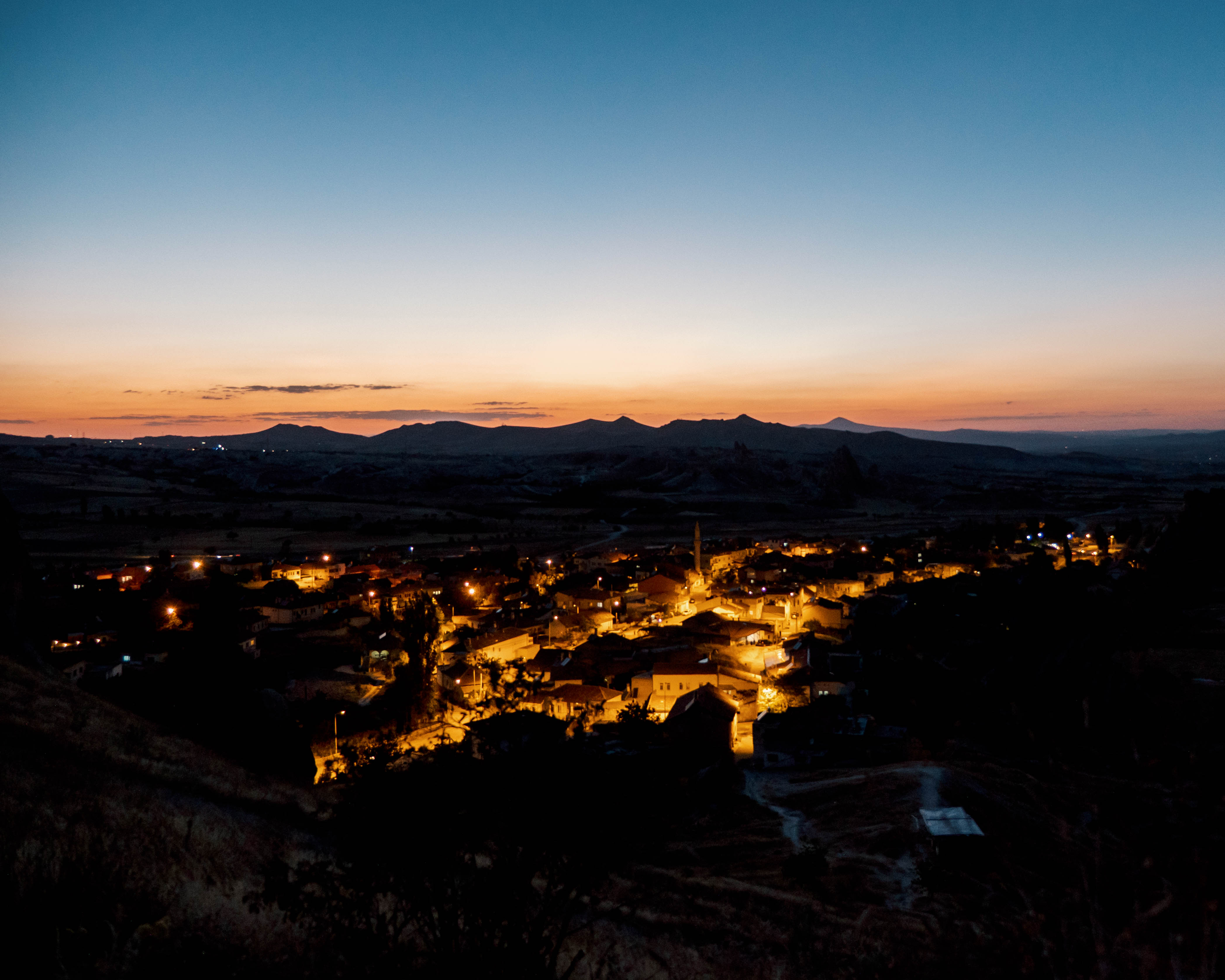 When the sun sets, village lights under the hills of Cappadocia turns on and creates a warm contrast to its surroundings.