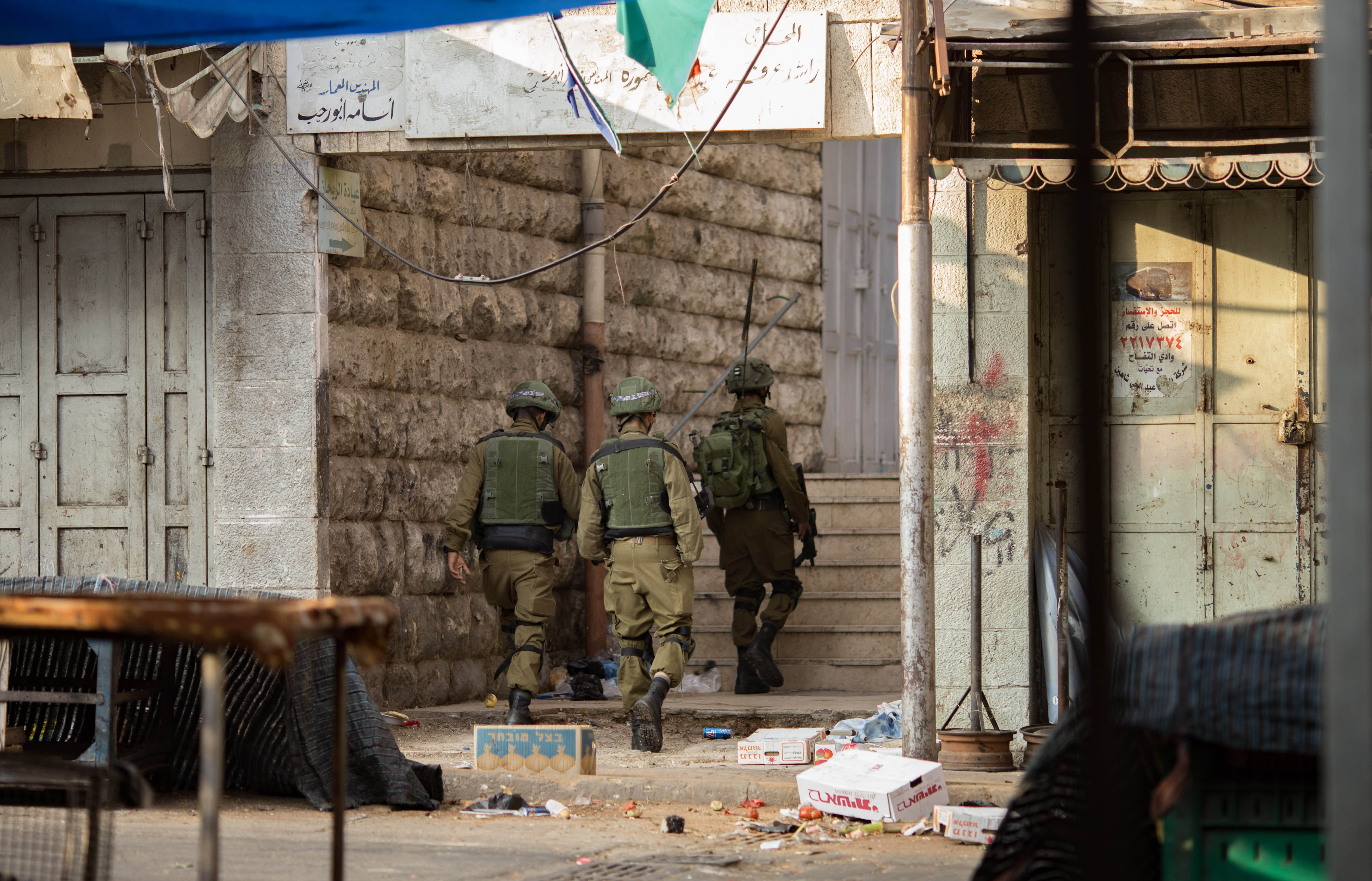 Israeli Defence Force soldiers patrol the markets of Hebron during a Friday demonstration. 