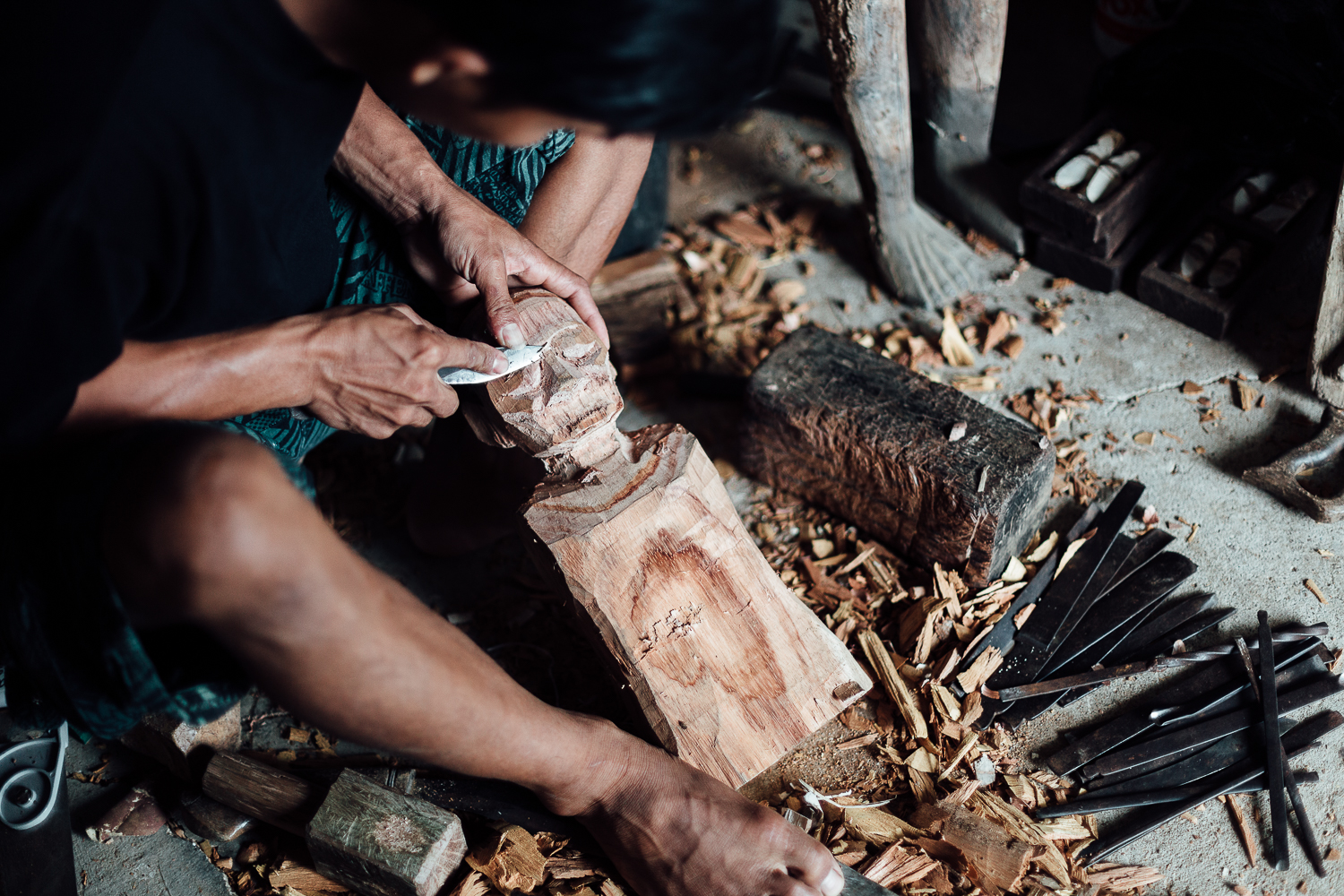 A man carves a 'tau-tau' representing the dead. After the ceremony, the body is carried in a coffin and buried in a cave dug in cliffs next to his ancestors. This sacred effigy is placed on a balcony built against the cliff and is believed to protect the living.