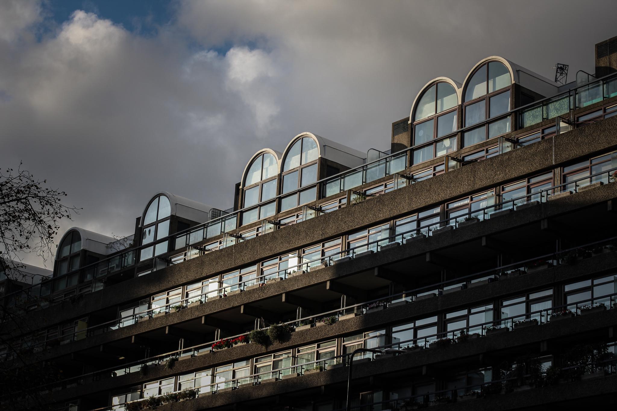 Exterior view of the Barbican, its iconic windows typical of the design of its architects. An autumnal sun, characteristic in London in this season, entering through the windows.