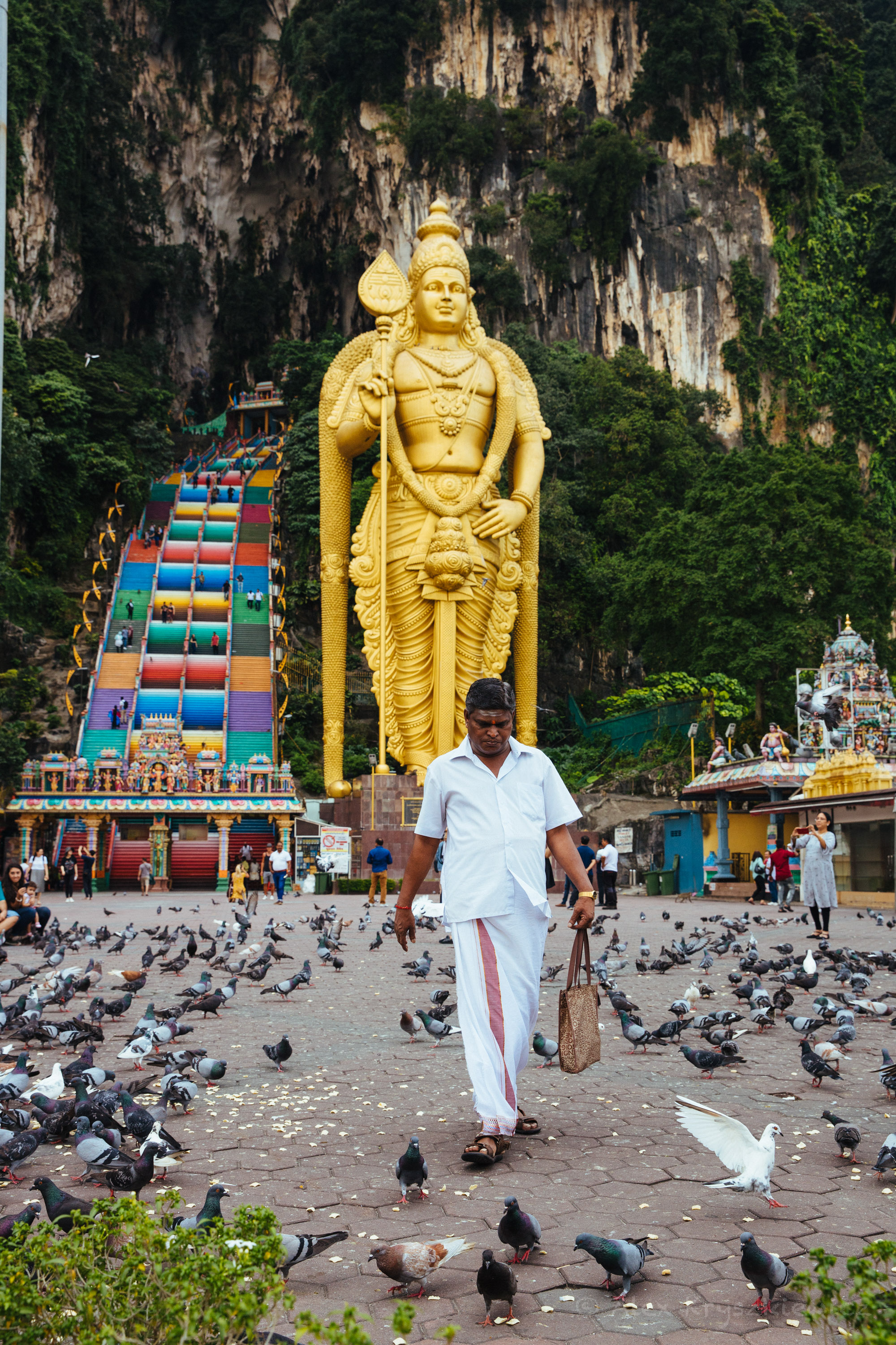 A visitor leaves the shrines and the bustling frenzy of life at Batu Caves