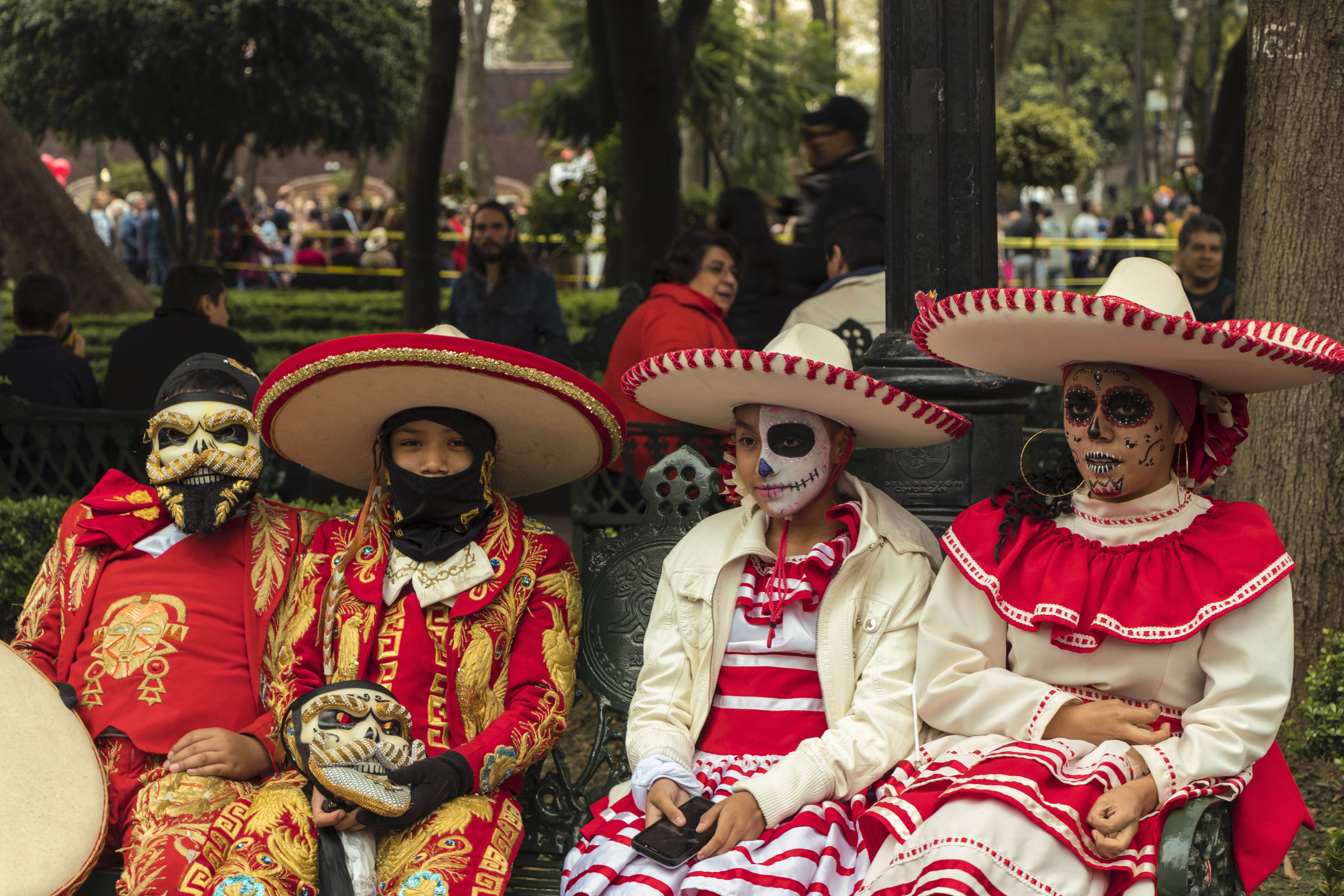 A family of Catrinas resting in park bench during Day of the Dead Festivities 