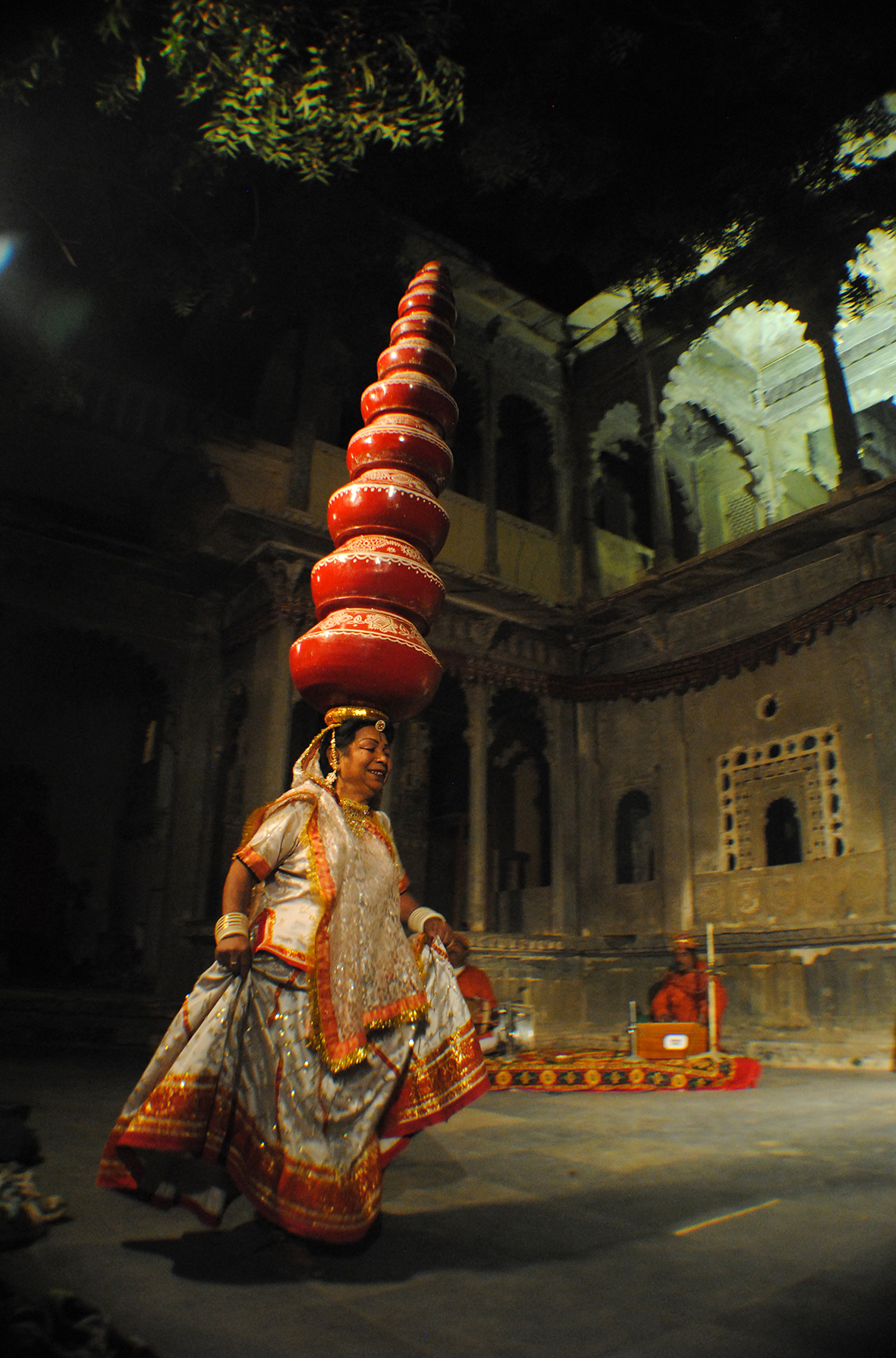 A woman performs the Bhavai, a ritualistic dance, balancing 9 earthen pots on top of her head while dancing.