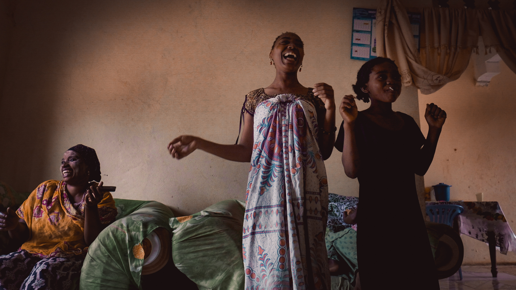 Imouda (center), her niece, and her aunt Eshati are practicing their party moves. Eshati is wearing a traditional sandalwood mask. It protects the skin from the sun and is known to be a great remedy against heat rashes. It is also considered a beauty enhancement.