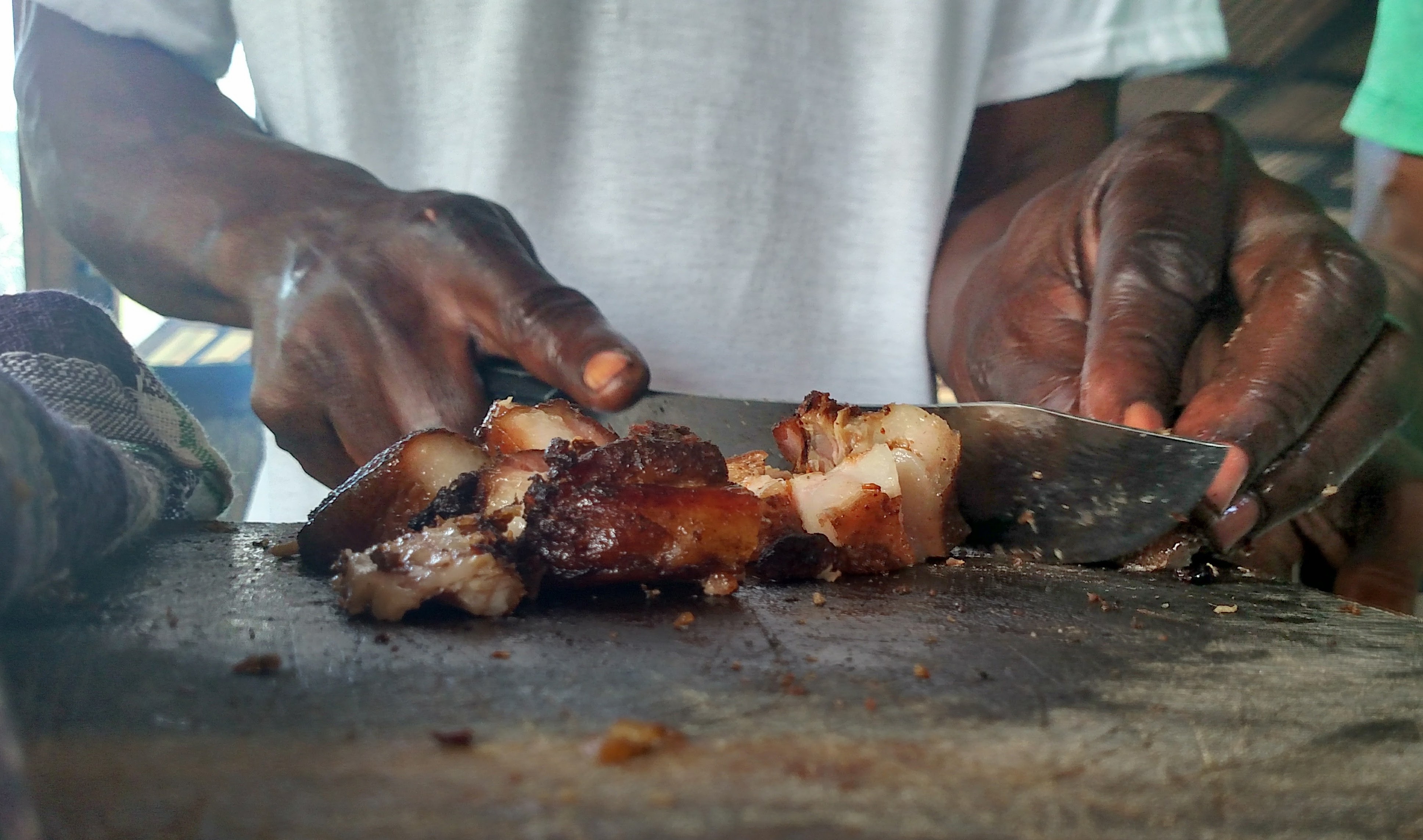 A butcher in Boston, Jamaica cuts up jerk pork for customers.