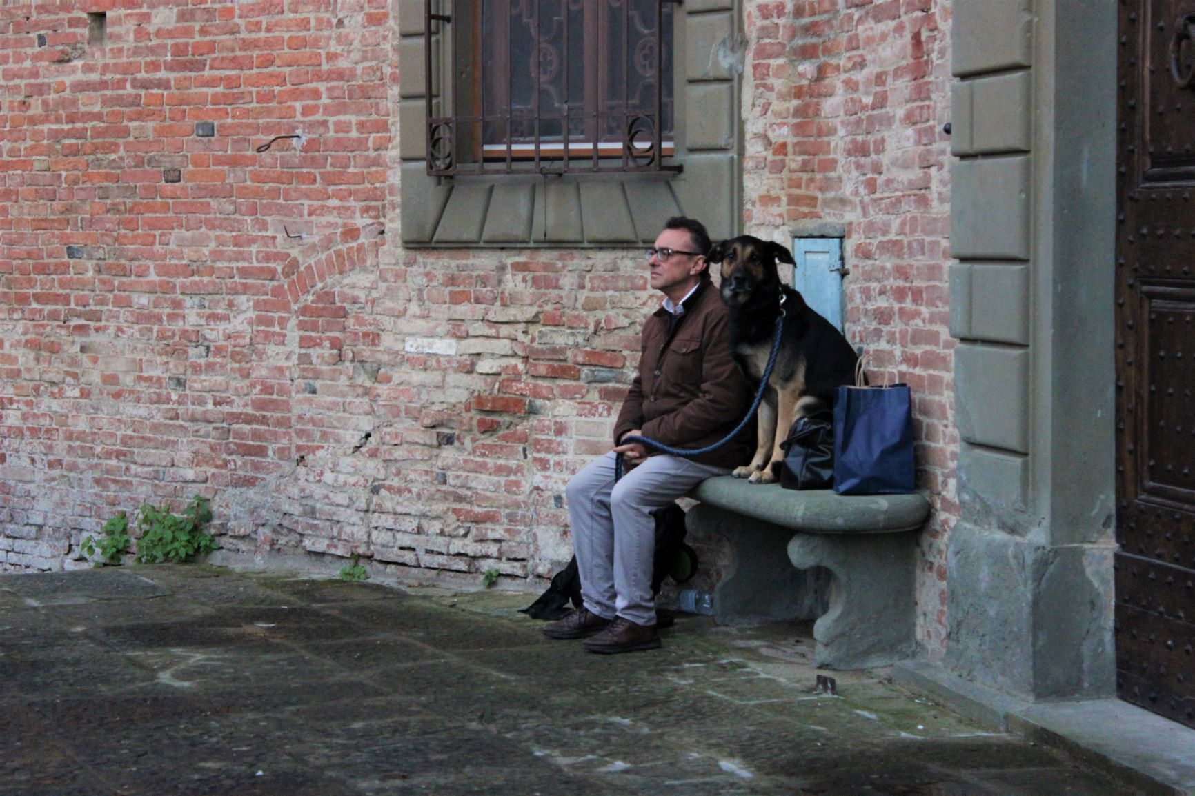 Two onlookers take a moment to quietly pause amidst the hubbub of the streets of San Miniato.