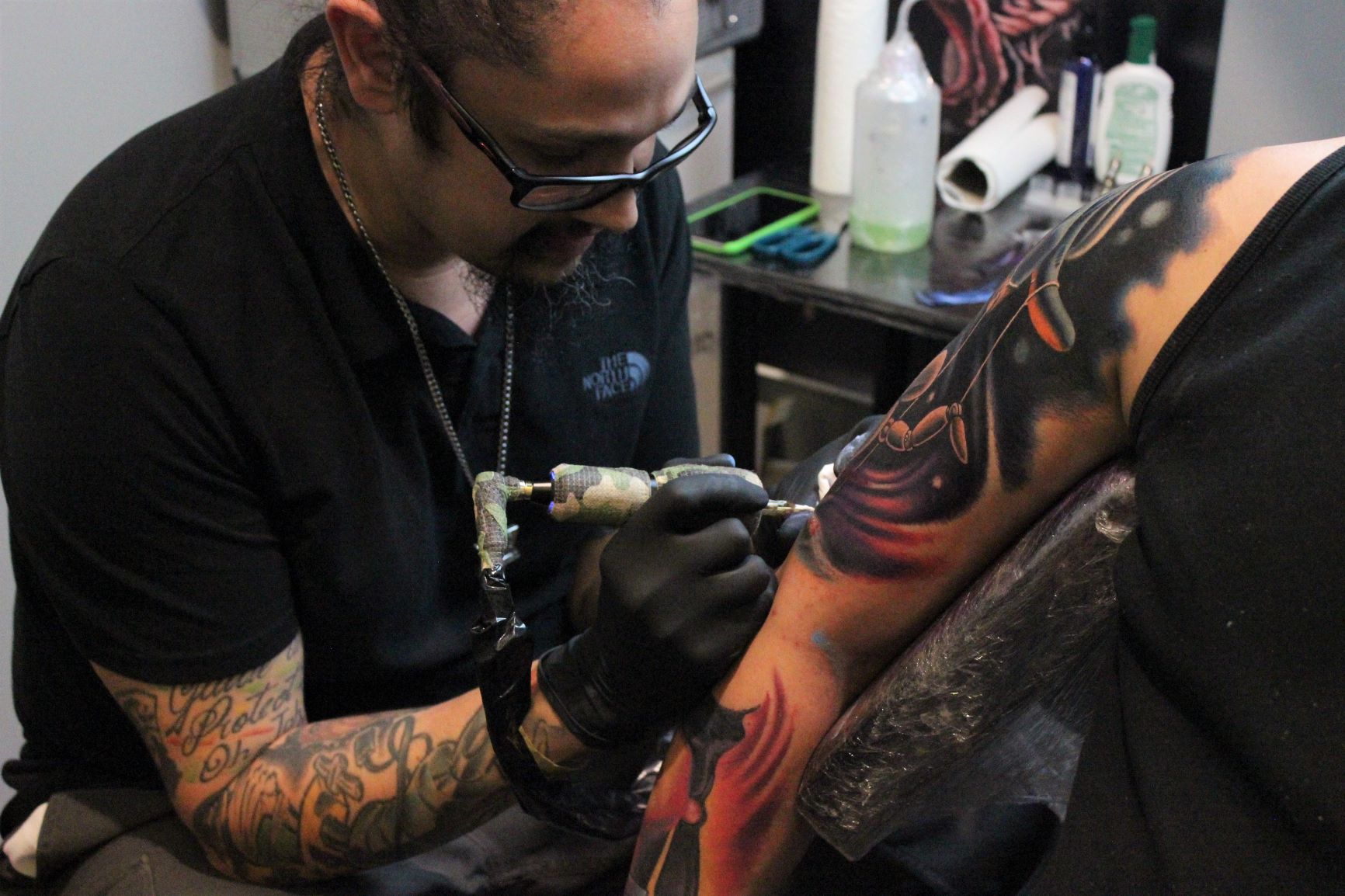 Barcelonan tattoo artist puts the final touches on the piece of a patron who has been sitting for seven hours at a tattoo convention outside the historic core of Florence.
