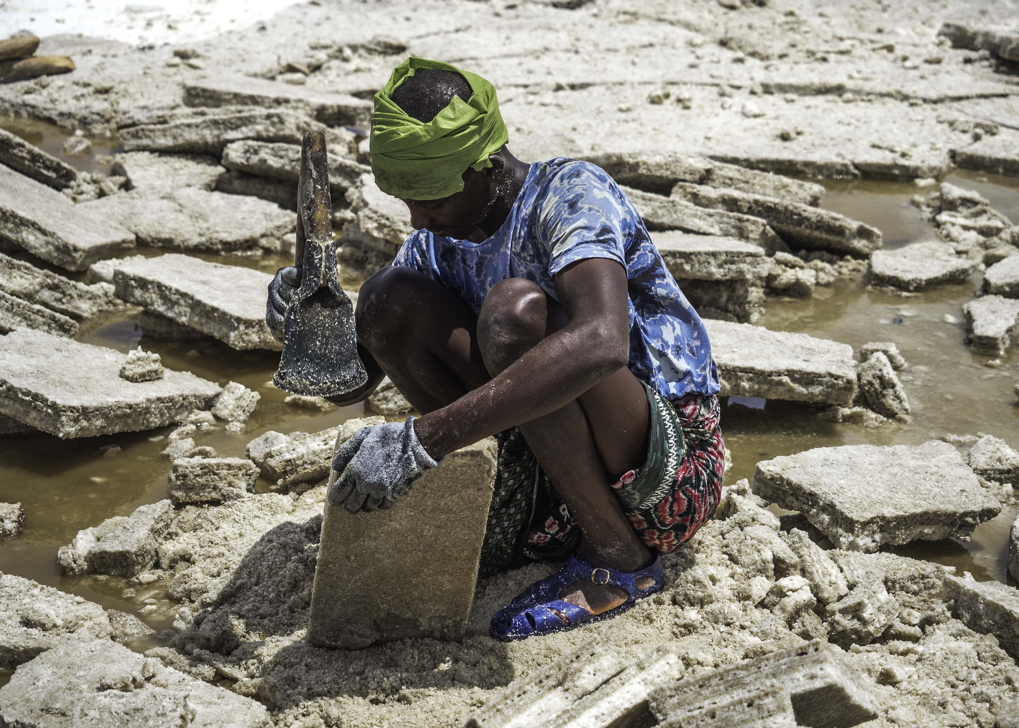 The Afar men cut slab after slab of salt into evenly shaped bricks while wearing what little protection they can afford. Drenched in salt and sweat they work tirelessly with hands and arms covered in cuts -- the pain and discomfort they overcome daily is a true testament to the strength of man.
