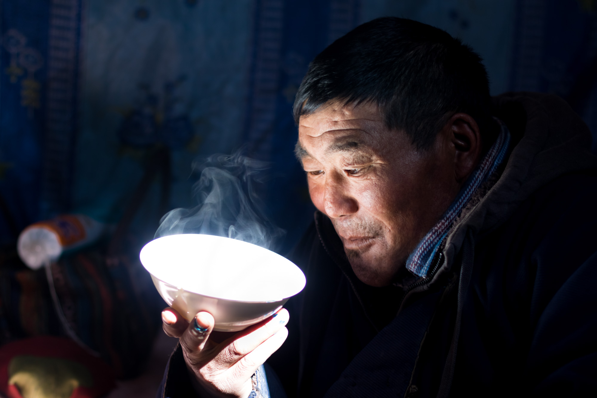 Jargal, an assistant herder, waits for his milk tea to cool down before sipping. Mongolian milk tea was popularized by Mongolian armies across the world during the height of the Mongolian Empire but has decreased in popularity for centuries, now mostly returning to being a local beverage.