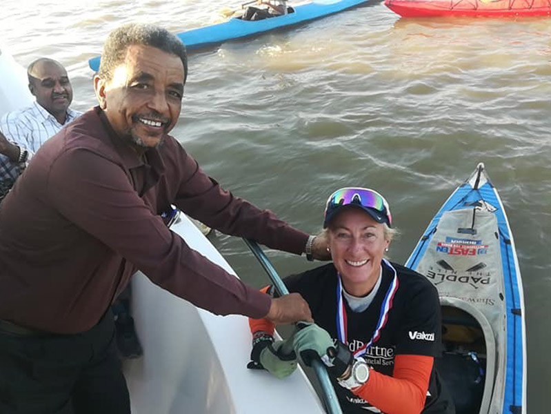 The President of the Olympic Committee for Sudan presents Sarah with a medal.