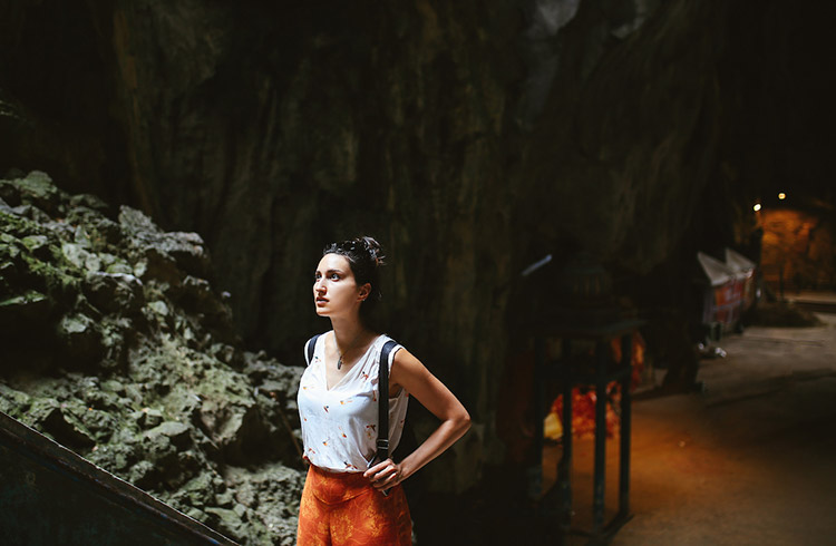 A woman sightseeing in Malaysia. She is walking through the famous Batu Caves in Selangore district