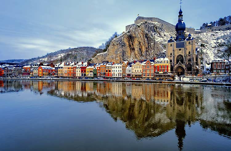 Collegiate Church and river Meuse in Dinant, Belgium during winter