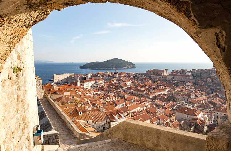 View of Dubrovnik from a stone archway looking out below to the water