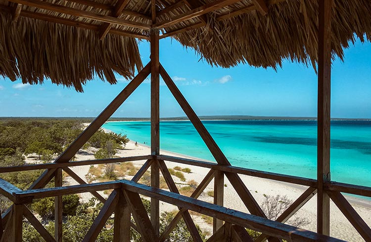 Clear water seen from a thatched-roof balcony