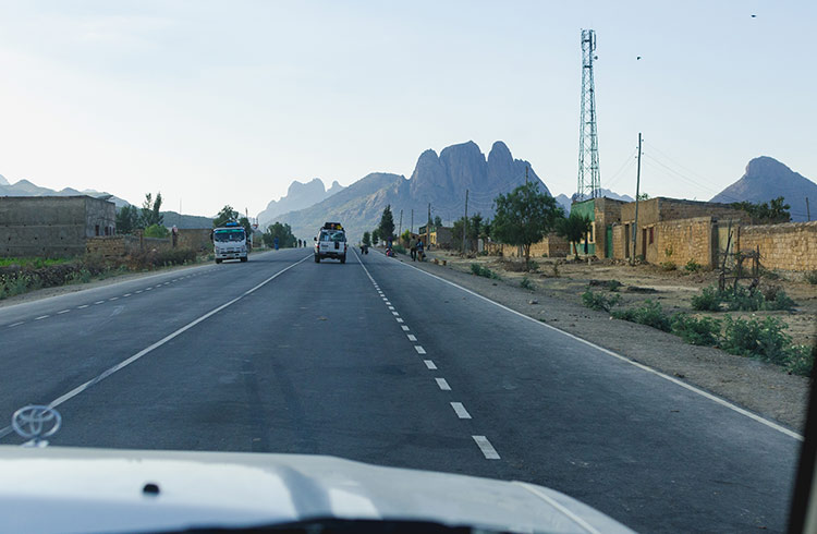 Driving on a road in Ethiopia looking out of a car, with mountains in the distance