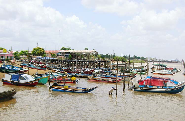 Boats moored in a murky brown river in Guyana