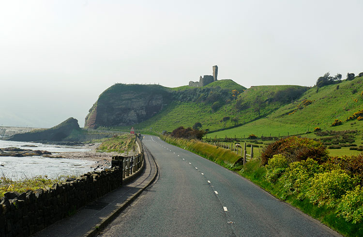 Rolling landscape and ruined castle at Glenariff, County Antrim of Northern Ireland