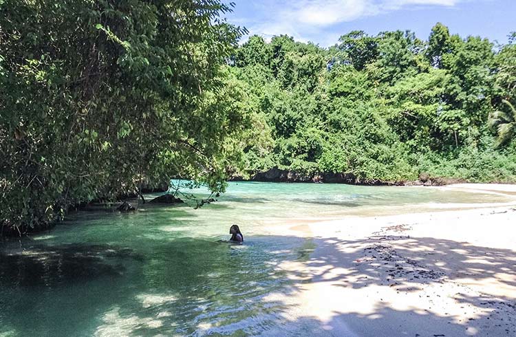 A woman sits in a clear lagoon in Jamaica