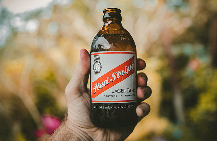 Holding up a Red Stripe beer in Jamaica