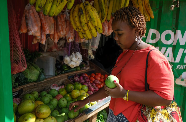 A woman selects produce at a fruit and vegetable market in Nairobi, Kenya.