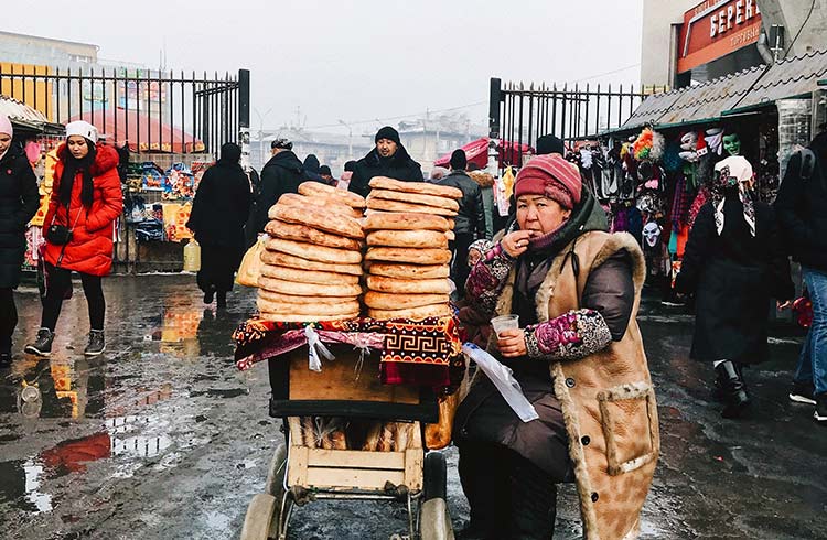 An old lady working in the bazar making Lepioshka (bread)
