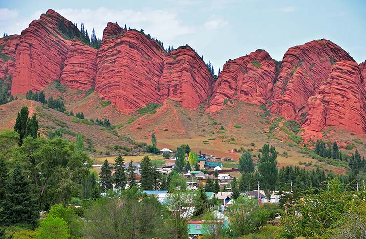 A view of the village of Jeti Oguz with famous red rock formations in the background in Kyrgyzstan