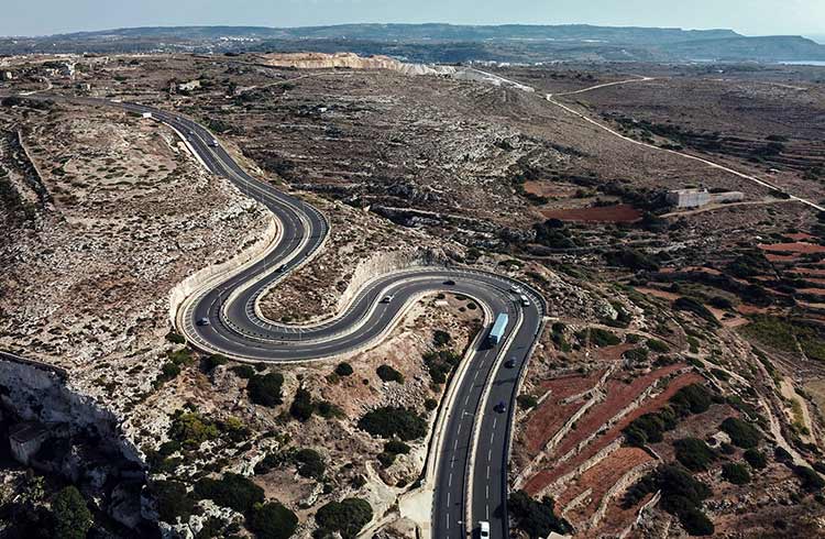 An aerial view of a winding road shaped as a letter S in the north of Malta