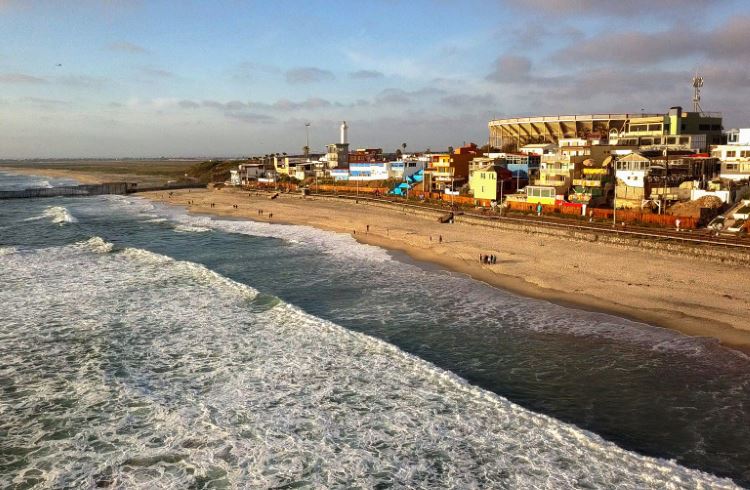 Aerial view of the beach and boardwalk near the international border wall in Tijuana, Mexico.