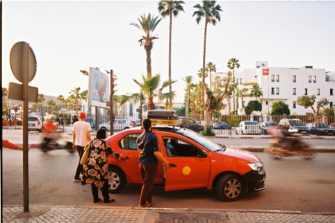 Catching a petit taxi at sunset, the daily rhythm of Moroccan city life.