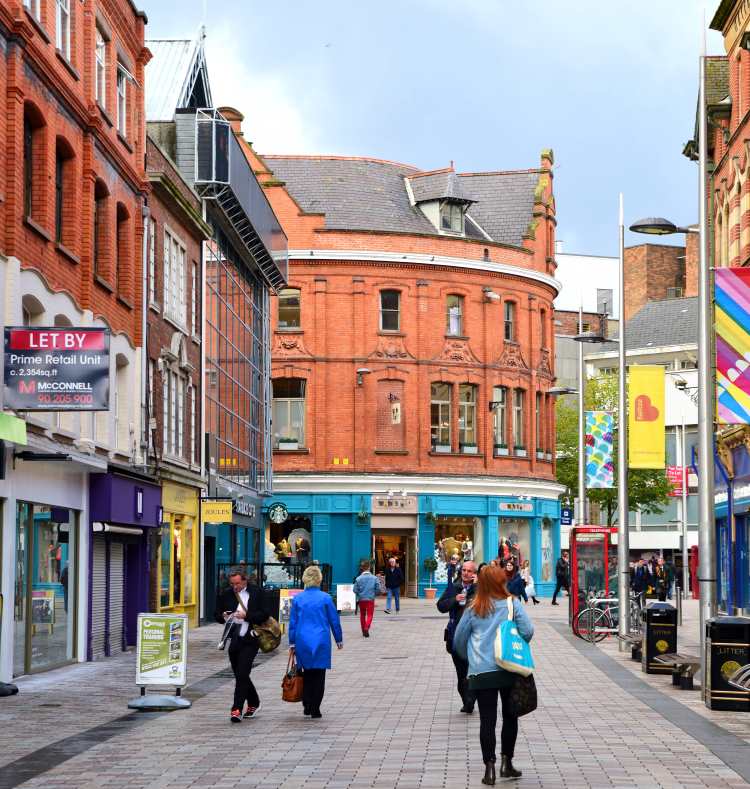 Shoppers stroll along a street in downtown Belfast, Northern Ireland.
