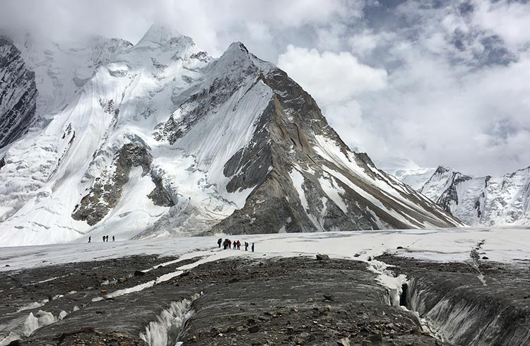 Group of trekkers crossing a glacier at the bottom of K2 mountain, Pakistan