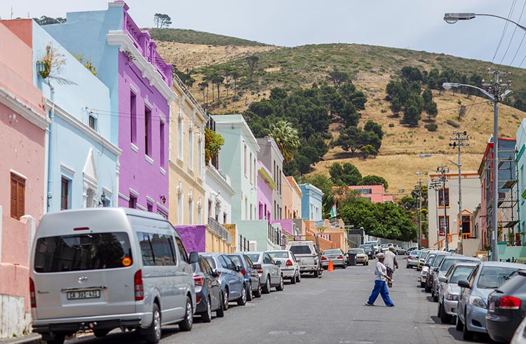 Colorful houses in Bokaap, Cape Town, with a hill in the background spotted with trees