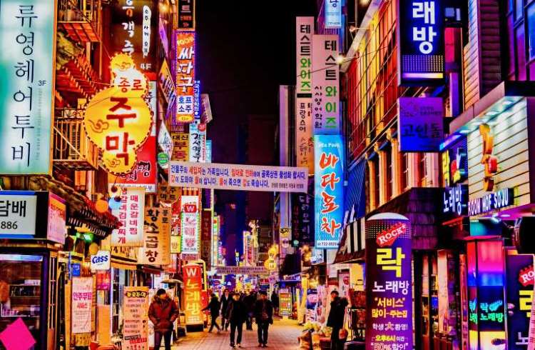Bright neon signs line a pedestrian street in downtown Seoul, South Korea.